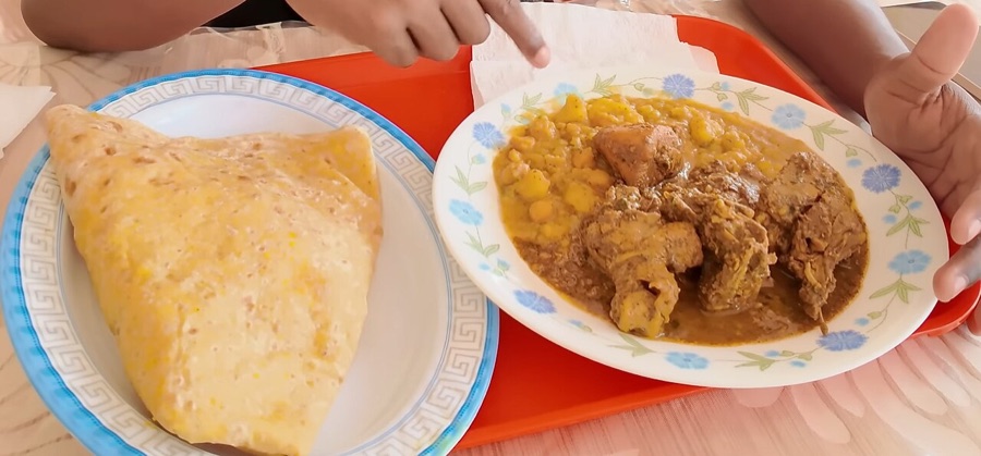 Dhal puri folded beside curry chicken with channa